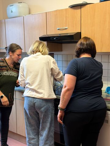 Drei Frauen von hinten am Herd beim gemeinsamen Ansetzen einer Rezeptur