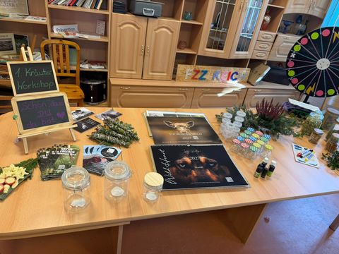 Tisch mit Flyern, Kalendern, Räucherbündeln und den Kreidetafeln zum Workshop
